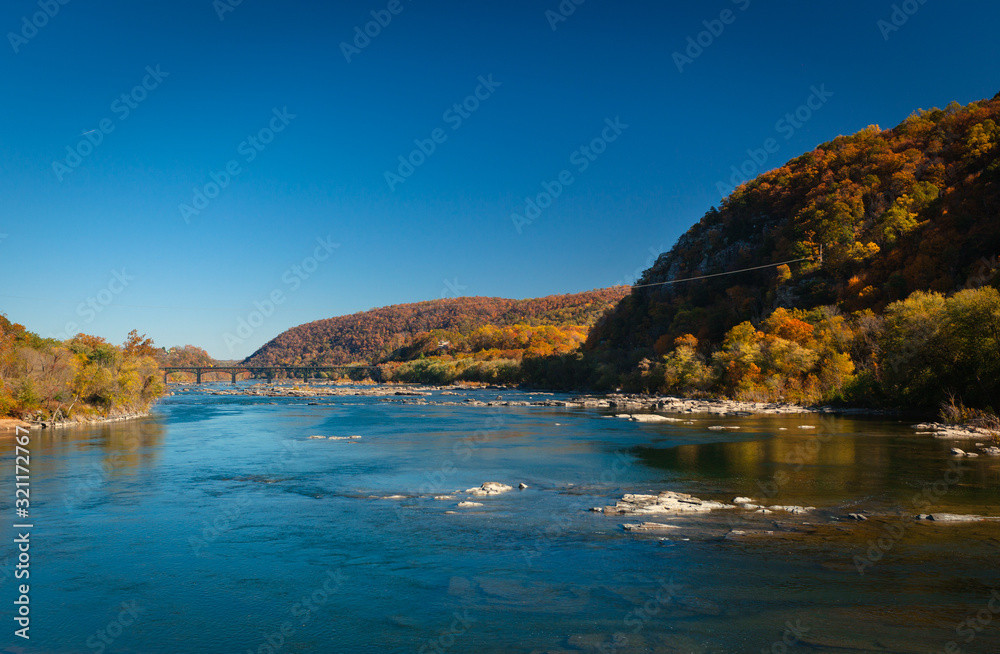 The Potomac River in Harper's Ferry, West Virginia, on a sunny Day with colorful Foliage on Trees