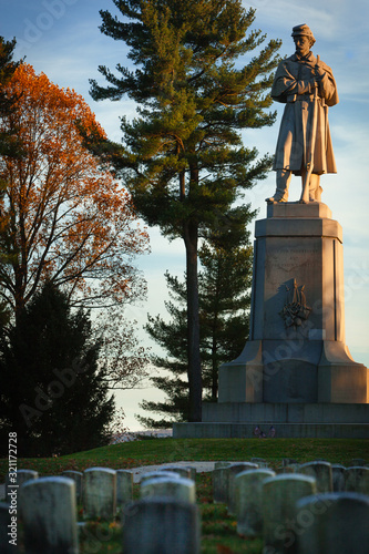 Private Soldier Monument at the Antietam National Cemetery in Sharpsburg, Maryland, USA with Headstoned in Foreground, Evening Light photo