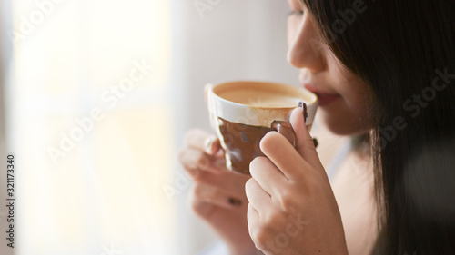 Close up view of a woman drinking morning coffee