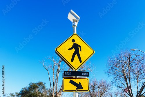 Pedestrian crossing sign with solar powered flashing lights. Crosswalk beacon provides advance notice of pedestrian activity for drivers