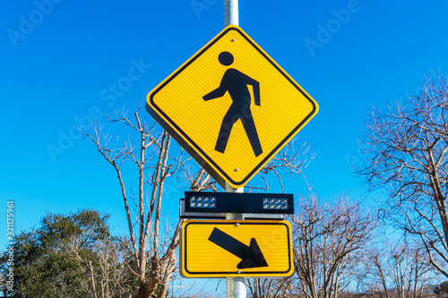 Pedestrian crossing sign with flashing lights. Crosswalk beacon provides advance notice of pedestrian activity for drivers