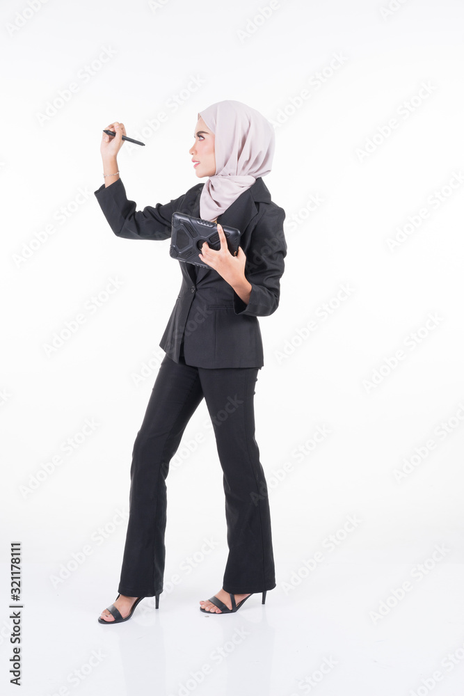 Obraz premium Full length portrait of an attractive Muslim businesswoman wearing hijab with tablet and gestures isolated on white. For image cutout for corporate, technology, business or finance.