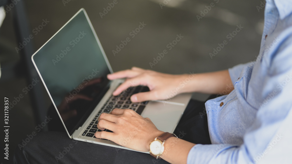 Side view of businessman using laptop on his lap Side view of businessman using laptop on his lap
