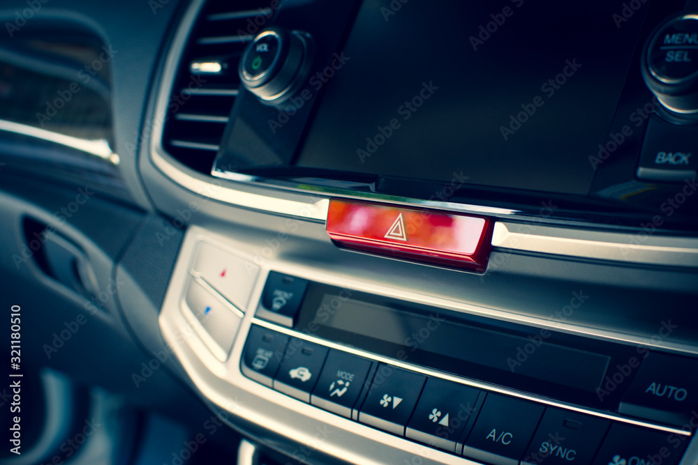Car emergency light button on dashboard in a car. Car emergency light button on dashboard in a car.