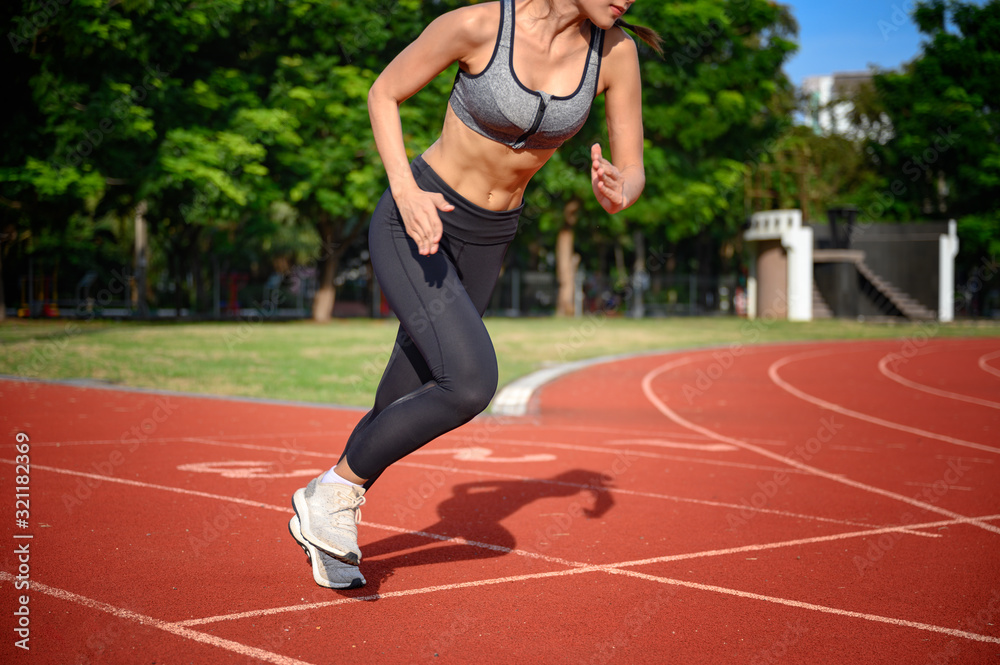 strong and healthy body of young woman sproty in the way of start practice running in sport stadium