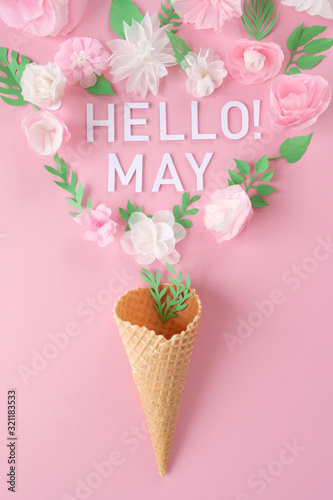 Waffle cone with paper flowers on dark background. Holiday concept.