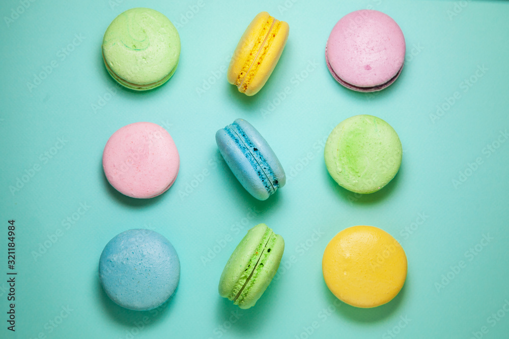 Obraz premium Different colorful macaroons on blue background. Square form