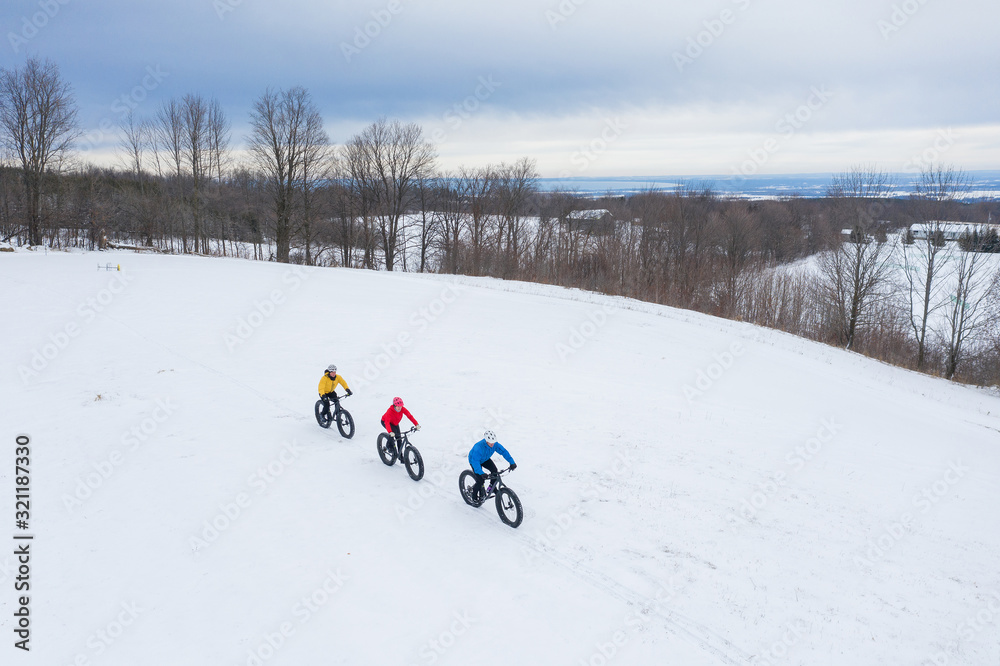 Aerial drone photo of a group of friends riding their fat bike in the snow in Ontario, Canada