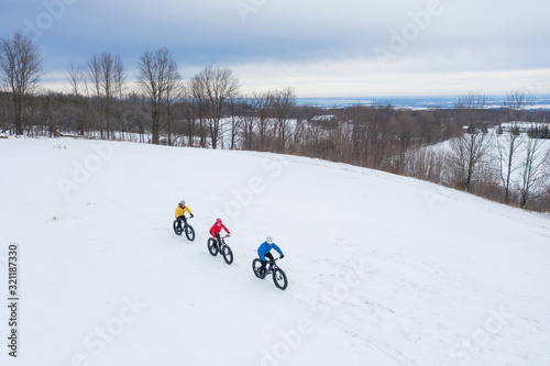 Obraz na płótnie Aerial drone photo of a group of friends riding their fat bike in the snow in Ontario, Canada w salonie