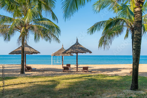 Fototapeta Naklejka Na Ścianę i Meble -  Tropical beach with palm tree and leaf umbrellas