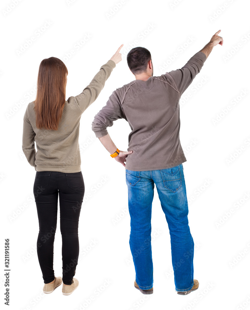 Fototapeta premium Back view of couple couple in sweater pointing.