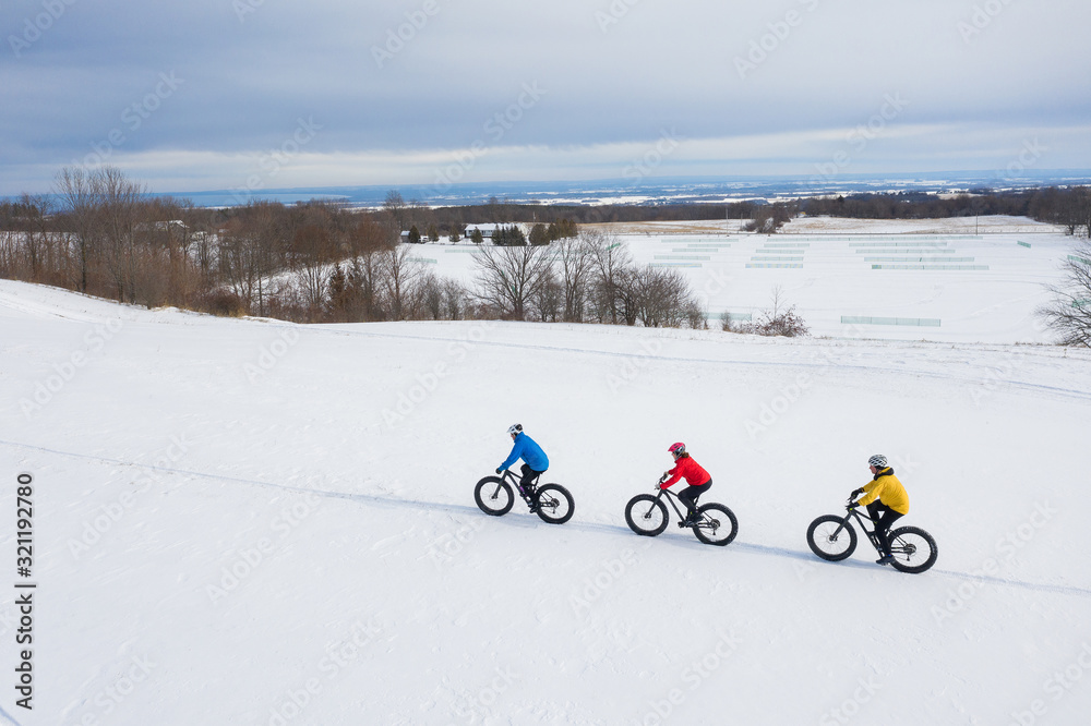 Aerial drone photo of a group of friends riding their fat bike in the snow in Ontario, Canada