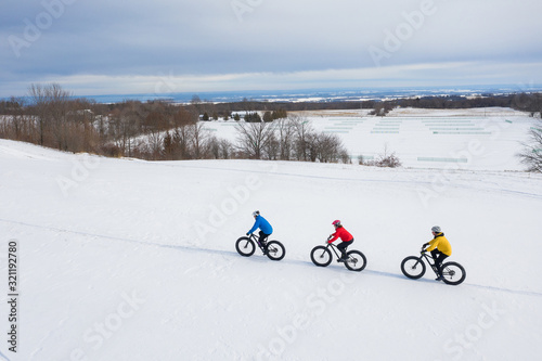 Obraz na płótnie Aerial drone photo of a group of friends riding their fat bike in the snow in Ontario, Canada w salonie