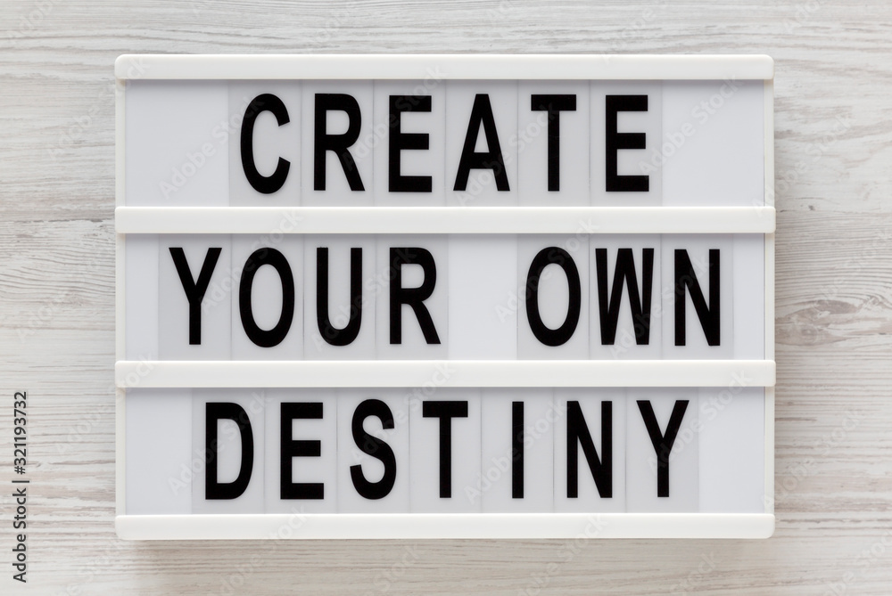 'Create your own destiny' words on a lightbox on a white wooden background, top view. Overhead, from above, flat lay. Close-up. 'Create your own destiny' words on a lightbox on a white wooden background, top view. Overhead, from above, flat lay. Close-up.