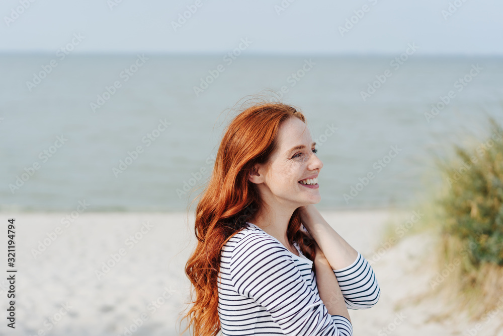 Pretty redhead woman enjoying a day at a beach