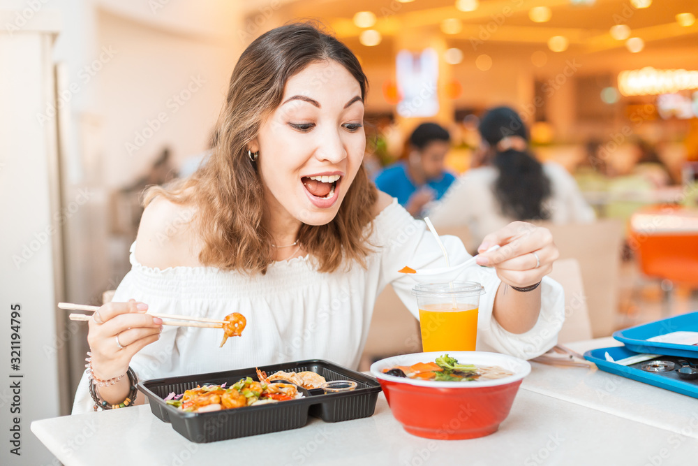 Asian woman eating Japanese bento lunchbox and miso soup in sushi bar