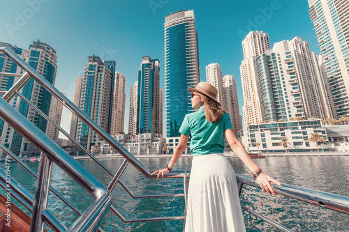 Photography Asian girl on a deck of cruise ship enjoying great view of skyscrapers of Marina