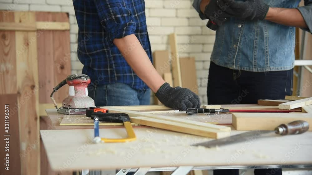 Young Asian group man worker using electric hand drill to build diy wood furniture in workshop Young Asian group man worker using electric hand drill to build diy wood furniture in workshop