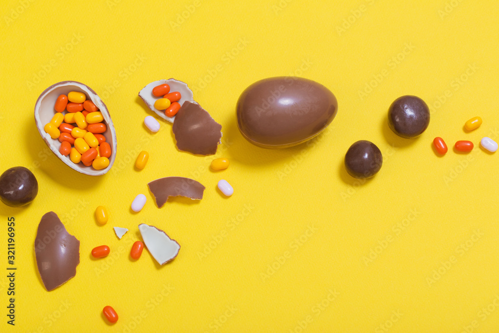 Easter yellow background with chocolatte eggs and  candy