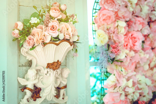 Many artificial pink and white roses are decorated on the wall to the backdrop in the wedding day. Beautiful flowers background, Selective focus.