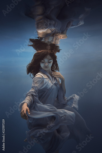 Portrait of a girl in a blue dress under water