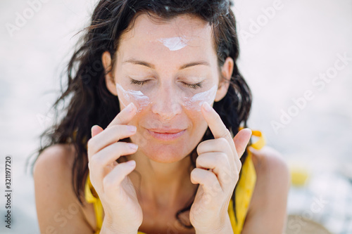 Woman with a suncream on her face