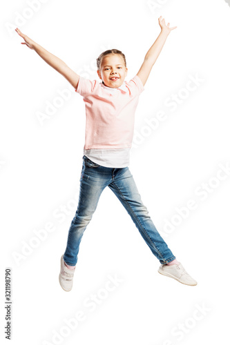 A school-age girl in jeans and a pink sweater is jumping. Isolated over white background. Vertical.