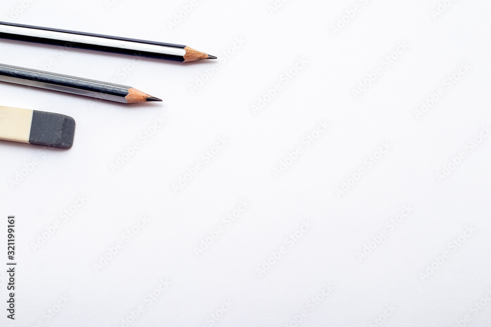 Pencils and eraser on white paper background. Copy space_ Pencils and eraser on white paper background. Copy space_
