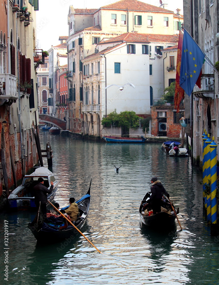 Venice, Italy, December 28, 2018 evocative image of a typical Venice canal with passing boats and gondolas