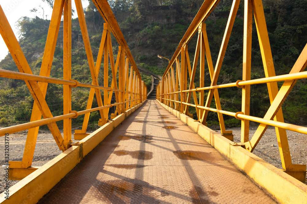 Yellow steel bridge over river in himachal pradesh in Kangra village, india Yellow steel bridge over river in himachal pradesh in Kangra village, india