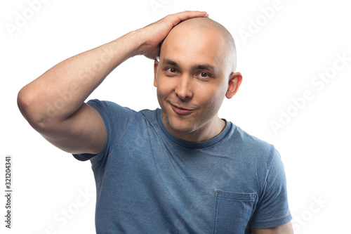 Portrait of happy bald man touching shaved head