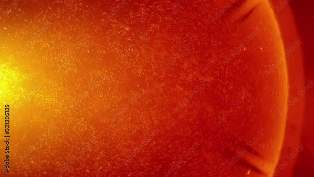 orange effervescent vitamin c flu tablet dissolving in a glass of water, sparkling and fizzing bubbles