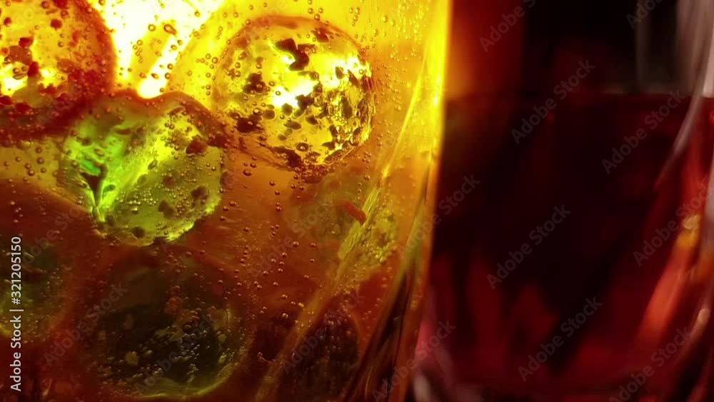 plastic colored ice round cubes and orange effervescent vitamin c flu tablet dissolving in a glass of water, sparkling and fizzing bubbles