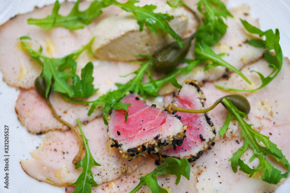 Sesame crusted tuna fish meat, smoked ham and arugula salad leaves
