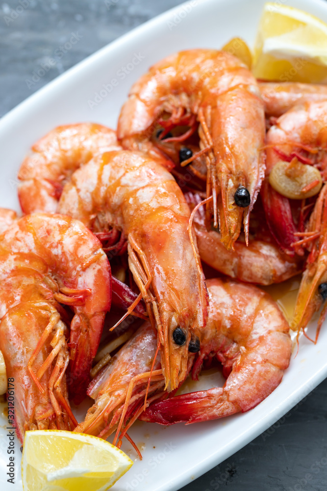 boiled shrimps with lemon on white dish on ceramic background boiled shrimps with lemon on white dish on ceramic background