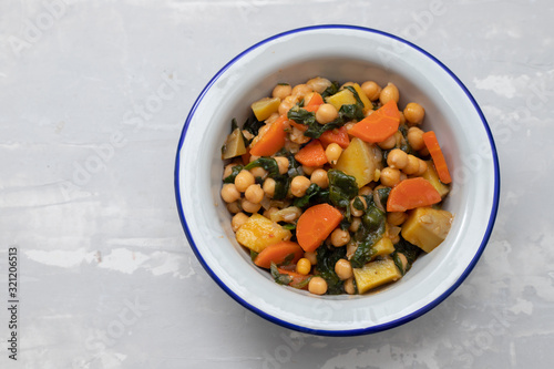 chick-pea with carrot and spinach on white bowl on ceramic backgeound