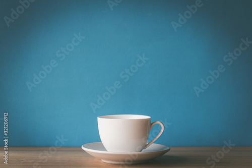 Valokuvatapetti cup of coffee on wooden table with blue background