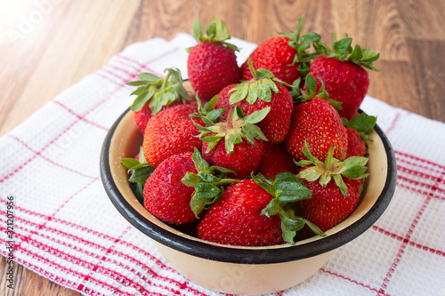 ripe red strawberry on a table in a bowl