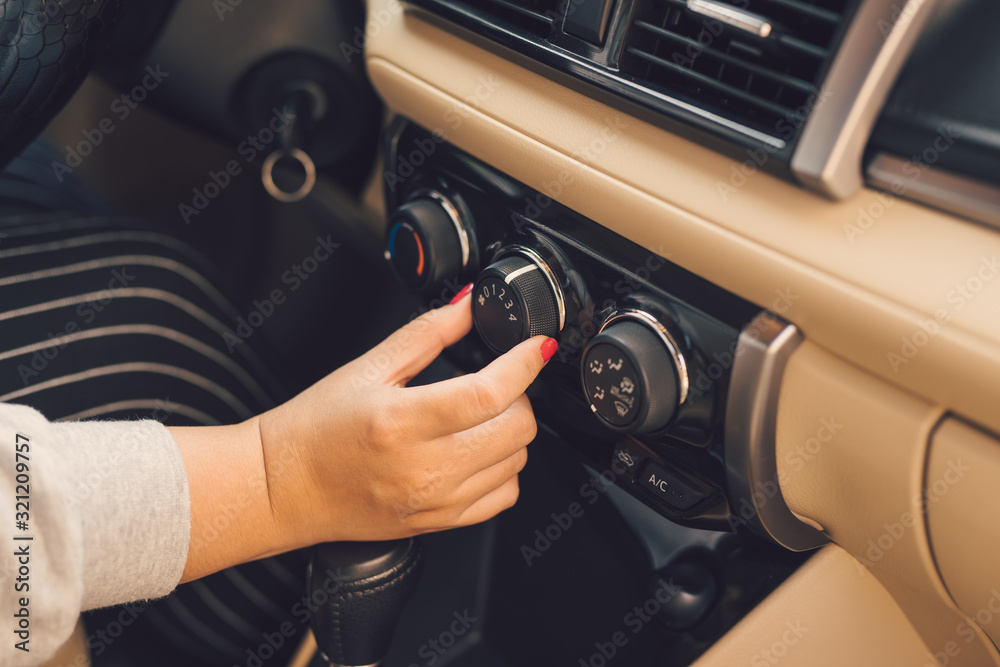vHand of woman turning on car air conditioning system,Button on dashboard in car panel vHand of woman turning on car air conditioning system,Button on dashboard in car panel