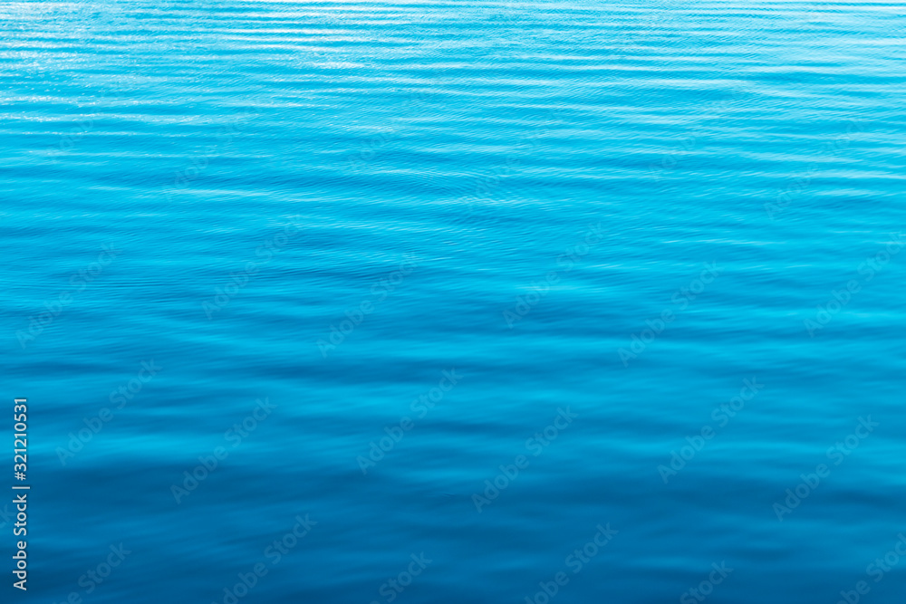 The surface of the blue calm sea with light ripples. The surface of the blue calm sea with light ripples.