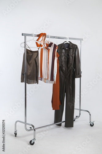 Rack for clothes with hanging things on a light gray background.