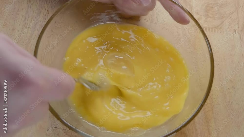 Slow Motion Shot of Whisking Eggs With a Fork in the Kitchen