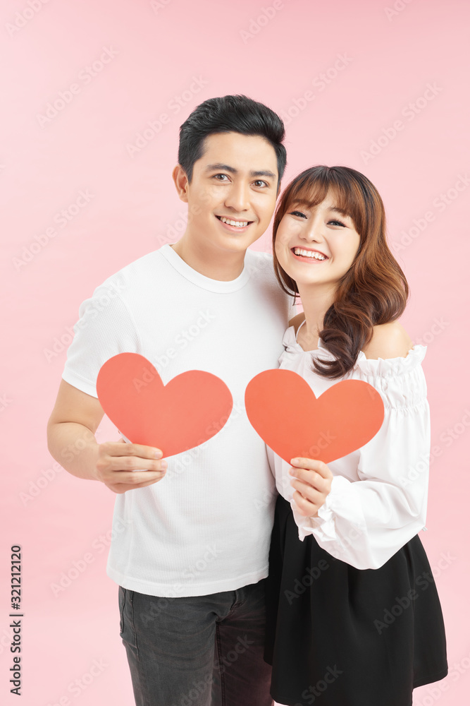 Young beautiful asian couple with present isolated on pink Young beautiful asian couple with present isolated on pink
