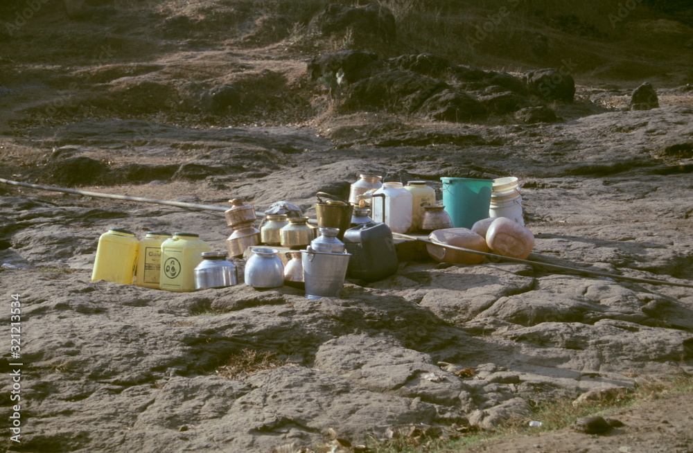 Utensils and containers kept in line before filling water at a community tap near Mandangad, Dapoli taluka. Maharasthra, India Utensils and containers kept in line before filling water at a community tap near Mandangad, Dapoli taluka. Maharasthra, India