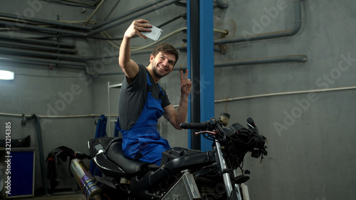 Technician sits on motorcycle and makes a photo 