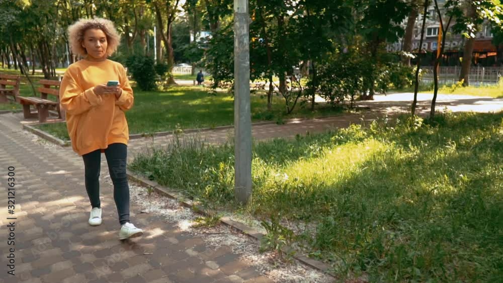 blonde woman walking on the street scrolling news feed in social media or chat online slow motion blonde woman walking on the street scrolling news feed in social media or chat online slow motion