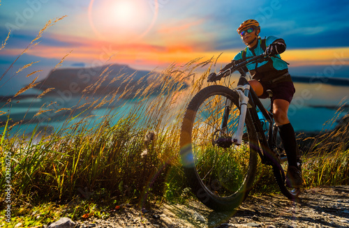 Fototapeta Naklejka Na Ścianę i Meble -  Cycling woman and man riding on bikes in Dolomites mountains andscape. Couple cycling MTB enduro trail track. Outdoor sport activity.