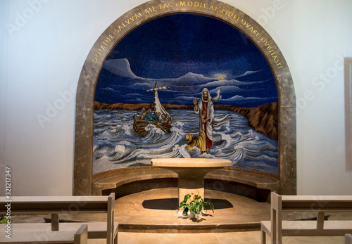 Magdala, Israel, January 26, 2020: Side altar in the church in Magdala on the Galilee Lake (Tiberiacn) with a mosaic depicting Jesus walking on the lake photo