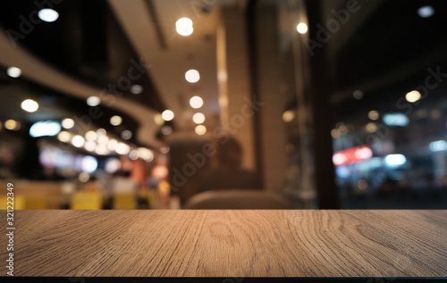 Empty dark wooden table in front of abstract blurred bokeh background of restaurant . can be used for display or montage your products.Mock up for space.