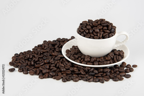 Coffee beans and white coffee cups on a white background.